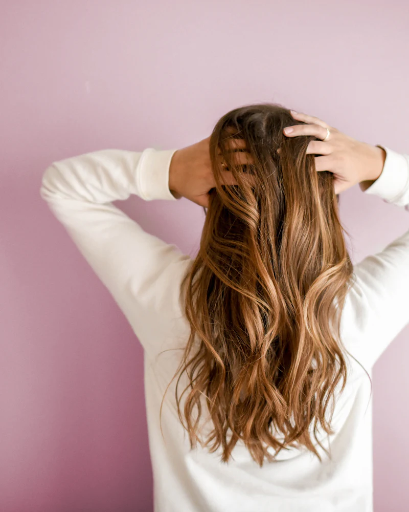 Back view of long brown hair with soft caramel pieces through the lengths